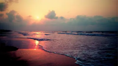 Soft light over the waves of a beach at dawn