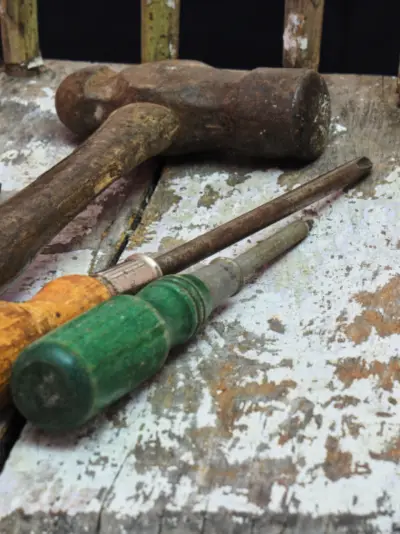 Old worn hand tools with wooden handles on a workbench
